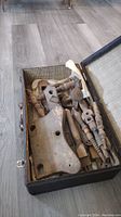 Top view of antique wooden parts for child's chair inside antique suitcase
