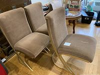 Group of six chairs arranged on hardwood floor with background items