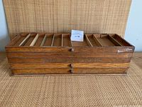 Overall front view of three stacked trays closed, showing wood grain and drawer knobs.