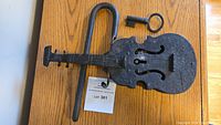 Top view of the entire lock showing violin shaped body, curved locking bar, and oversized key