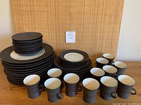 Full set shown with dinner plates, salad plates, coffee mugs, and saucers arranged for display.