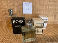 Group shot of four perfume and aftershave items showing bottles and boxes.
