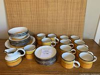 Overview of all dinnerware pieces including plates, bowls, mugs, cups, saucers, creamer, sugar dish