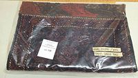 Folded saddlebag panels in protective plastic bag with lot label and handwritten tag