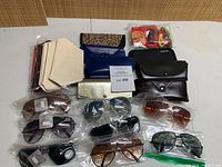 Overview of sunglasses, cases, pouches and straps arranged on table