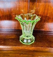 Front view of the green uranium glass vase showing its fluted, scalloped top and octagonal base.