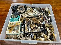 Overview of mixed jewelry lot in plastic container