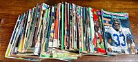 Photo showing the large stack of vintage Sports Illustrated magazines laid flat on a wooden surface from the top view to highlight the quantity and variety of issues.