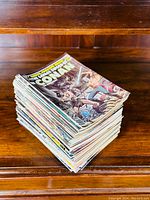 Stack of about 70-80 Conan comic magazines with visible well illustrated covers showing Conan in combat scenes.
