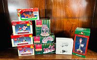 Photo showing all boxed figural ornaments including Lemax Dickensville, Norwood Hills, and Dept. 56 pieces arranged on shelf.