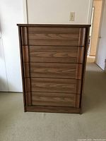Front view of closed 5 drawer oak veneer high boy dresser showing solid molding and wood grain patterns.