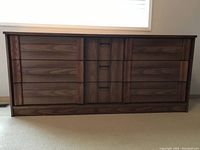 Front view of 9 drawer oak veneer dresser with solid molding and wooden drawer fronts.