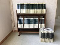 Two shelves holding the 1968 World Book Encyclopedia volumes with additional Year and Science Year Books alongside the wooden book case.