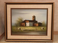 Full view of the framed oil painting depicting a rustic farmhouse with a silo, set in a grassy field with wooden barrels in foreground.