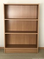 Front view of the light oak veneer bookshelf showing all three shelves including two adjustable ones.