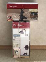 Two boxes stacked: top is Price Pfister Ashfield single control lavatory faucet, bottom is Price Pfister shower set with showerhead, valve, tub spout in oil rubbed bronze finish