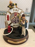 Close-up of the Precious Rescue figurine showing firefighter, woman, fire hydrant, and Fire Dept emblem.