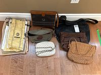 Overview of seven handbags and purses with Fendi dust bags stacked on left