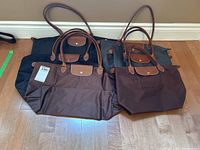 All six bags arranged on floor showing three large in back row and three small in front