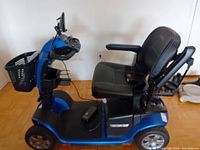 Side profile of blue Pride Victory 10.2 scooter showing seat, basket, wheels and scuffs
