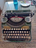 Photo of the green Underwood typewriter showing QWERTY round keys and some wear.