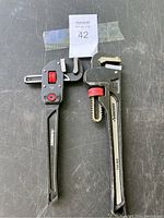 Two Husky adjustable pipe wrenches side by side on a surface with lot number paper.