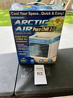 Front view of Arctic Air Pure Chill 2.0 box showing branding and key features like adjustable speeds, personal space cooler, lightweight and portable design.