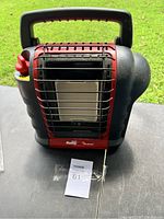 Photo of Mr. Heater Portable Buddy Propane Heater front view showing heating element and protective grill, with branding and control knob visible.