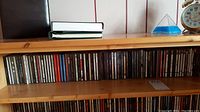 Shelf with approximately 85 CDs arranged horizontally