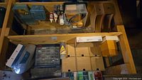 Wood storage, screws, nails, assorted hardware items, and spray paint within wooden boxes and compartments.