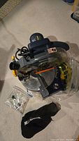 Mastercraft 8 1/4 inch compound mitre saw laid on floor with plastic bag and black dust collection bag