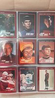 Front pages of the Star Trek collectible cards inside plastic sleeves showing various character faces and names.