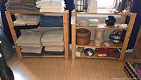 Photo showing two wooden storage shelves side by side, each loaded with folded fabric and storage baskets (not included).