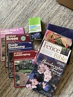 Photo showing six gardening and landscaping books, titles clearly visible, arranged on carpeted floor.