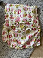 Two owl print pillow covers and one curtain panel showing owl print fabric and design.