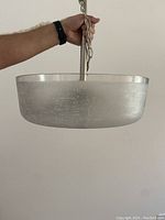 Front and side view of the pendant light showing frosted glass shade with crosshatch etching and metal suspension rod and chain