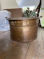 Full side view of the large vintage copper pot showing shape, handles, and patina.
