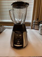 Photo of Oster blender showing glass jar, black lid, and stainless steel base with control panel