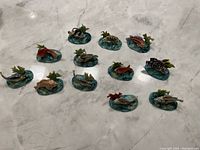 Photo showing all 12 Dresden Saxony colorful fish figurines arranged on a surface, highlighting their varied colors and aquatic base designs.