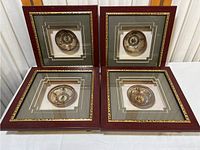 Set of four shadowbox frames each containing a hand-painted Chinese ceramic bowl with calligraphy and seasonal imagery.