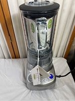 Full view of the blender showing the glass pitcher with handle, black lid, and stainless steel base with digital display.