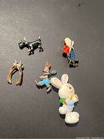 Photo of all 5 vintage pins: black scottie dog, gold horseshoe, rabbit in blue pants, large white rabbit with chick, girl with heart balloon 'Love'.