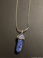 Close-up of the lapis lazuli gemstone pendant in silver tone setting showing color and shape details.