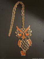 Photo of the vintage 1970s gold-tone owl pendant necklace showing the full chain and the owl pendant with enamel details.