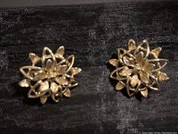 Front view of both filigree flower earrings, showing intricate multi-layered petal design in gold tone metal.