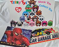Photo showing the Spider-Man retail sign header featuring Spider-Man character on a cityscape background, Ty Beanies sign header with colorful plush animal illustrations, and NASCAR Garage Area sign header with race car graphic.
