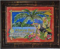 Front view of the framed colorful lithograph print titled Mango Bay, containing tropical elements and text.