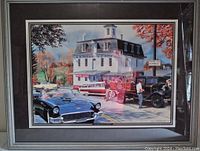 Framed artwork showing classic Ford and Lincoln vehicles with a vintage building background and signatures near the bottom.