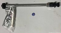 Metallic power washer tool with black plastic nozzle and adjustment knob, partially wrapped in plastic.