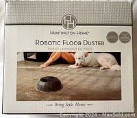 Front of box showing Huntington Home robotic floor duster image with dog in background